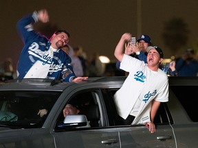 People celebrate during a drive-in viewing of Game 6 of the World Series in the parking lot of Dodgers Stadium in Los Angeles October 27, 2020.