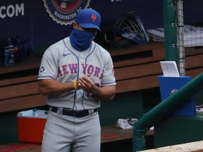 Mets manager Luis Rojas uses hand sanitizer in the dugout after making a pitching change against the Nationals in the second inning at Nationals Park, in Washington, D.C., Sept. 27, 2020.