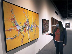 Jennifer Matotek, executive director of the Art Gallery of Windsor, stands next to an Alex Janvier original hanging at the AGW last year. The gallery is kicking off a new series of monthly panel discussions Thursday with a conversation about how the community can mark Canada's newly created  National Day for Truth and Reconciliation.