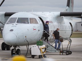 Passengers disembark an Air Canada flight at the Windsor International Airport, Friday, Oct. 30, 2020.