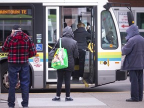 Passengers board a Transit Windsor bus outside the Windsor International Transit Terminal, Monday, Oct. 26, 2020.  Today is the first day passengers are boarding at the front of the bus since safety protocols were put in place for COVID-19.