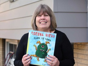 Pam Stradeski of LaSalle holds up her new children's book, Corona Virus Came to Town. Photographed Oct. 11, 2020.