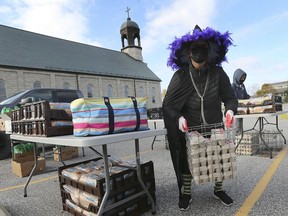 Dressed up for Halloween, Kathy Beaudoin hauls a load of eggs to give away during a drive-thru food pickup event on Saturday, Oct. 31, 2020, at the McGregor Community Centre.