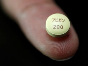 FILE PHOTO: A tablet of Avigan - drug approved as an anti-influenza drug in Japan and developed by Toyama Chemical Co, a subsidiary of Fujifilm Holdings Co, is displayed during a photo opportunity at Fujifilm's headquarters in Tokyo, October 22, 2014.