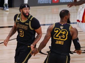 Lakers' Anthony Davis (left) reacts with teammate LeBron James during second half NBA Finals Game 2 action against the Heat at AdventHealth Arena at ESPN Wide World Of Sports Complex in Lake Buena Vista, Fla., Friday, Oct. 2, 2020.