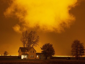 An old farm house is illuminated from greenhouse lights on Highway 77, north of Leamington, Tuesday, Oct. 27, 2020.