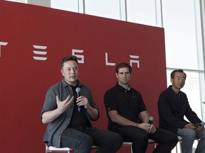 Billionaire Elon Musk, chief executive officer of Tesla Motors Inc., left, speaks as Jeffrey Straubel, chief technical officer and co-founder of Tesla Motors Inc., center, and Yoshihiko Yamada, consultant at Panasonic Corp., look on during a press event at Tesla's new Gigafactory in Sparks, Nevada, U.S., on Tuesday, July 26, 2016. Tesla officially opened its Gigafactory on Tuesday, a little more than two years after construction began. The factory is about 14 percent complete but when it's finished, it will be about 10 million square feet, or about the size of 262 NFL football fields.