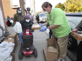 A woman receives an apple pie from local businessman Rob Katzman on Tuesday, Oct. 6, 2020, at the Men for God United Food Bank. As part of a Thanksgiving season charity donation by downtown retail pot shop Greentown, Katzman and other family members handed out nearly 200 pies at the downtown food bank.