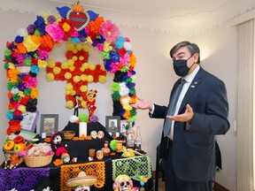 Alberto Bernal Acero, Consul of Mexico admires the variety of submissions for the Day of the Dead shrine at his office in Leamington Monday.  Photos of Bonifacio Eugenio-Romero and Rogelio Muñoz Santos — two migrant workers who died this summer in Windsor-Essex after falling ill with COVID-19 have been added to the shrine. Every year for Day of the Dead, which is a holiday on Nov. 2 in Mexico, the consulate creates a shrine and this year Cristina Amaya's group offered to set it up.