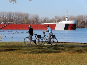 Under beautiful weather conditions, Sue Cullen and Bob Makar park their rides at Stop 26 Beach Monday. Lake freighter Great Republic was docked nearby to unload its cargo.
