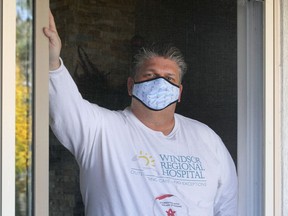 Windsor Regional Hospital CEO David Musyj in spending 14 days quarantined at his home. Musyj is photographed through the screen door looking to his backyard.