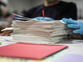 Gwinnett County election workers handle ballots as part of the recount for the 2020 presidential election at the Beauty P. Baldwin Voter Registrations and Elections Building on November 16, 2020 in Lawrenceville, Georgia.