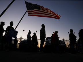 Supporters of  Democratic presidential nominee Joe Biden gather outside the Chase Center in Wilmington, Delaware, on Friday, Nov. 6, 2020, where  Biden was expected to make an announcement to the nation. Votes were still being counted Friday night and a winner still not declared in Biden's race for the White House against incumbent U.S. President Donald Trump.