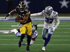 Chase Claypool of the Pittsburgh Steelers runs the ball past Trevon Diggs and Jaylon Smith of the Dallas Cowboys in the fourth quarter at AT&T Stadium on November 08, 2020 in Arlington, Texas.