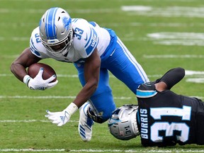 Kerryon Johnson of the Detroit Lions is tackled by Juston Burris of the Carolina Panthers during the first half at Bank of America Stadium on November 22, 2020 in Charlotte, North Carolina.