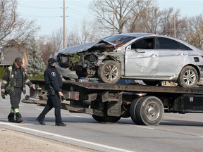 A Windsor police officer and a towing operator view a wrecked Hyundai Sonata sedan in the 2000 block of Front Road, near the River Canard bridge Thursday.  All lanes of Front Road N. were shut down for six hours as Windsor Police investigated.   The vehicle was originally northbound on Front Road and crossed the centre line. After striking a culvert, the vehicle narrowly missed a hydro pole and a natural gas meter before settling into the west ditch.