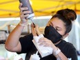 Gen Martinez is shown Sept. 4, 2020, applying chocolate topping to vegan Churros during WindsorEats Outdoor Food Hall event at Lanspeary Park.