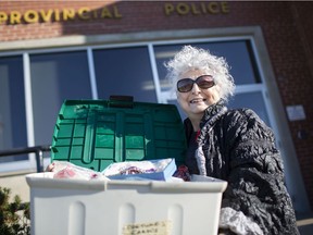 Carol Briese, 75, picks up her lost bin of costume jewelry outside the Lakeshore OPP detachment, Wednesday, Nov. 11, 2020.