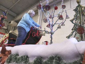 Volunteer Bonnie Kozma works on a Christmas parade float in Tecumseh on Friday.