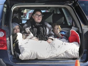 Danica Georgiou and her kids Keigan and Calum Clark take in a drive-in movie in a plaza on Dougall Ave. on Saturday, October 31, 2020. The charity event was sponsored by the CIBC Run for the Cure organization.