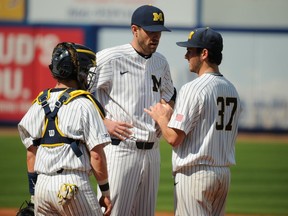 The Detroit Tigers have hired Chris Fetter, right, as it's pitching coach from the University of Michigan.