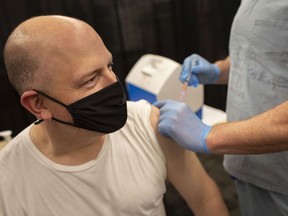 Mayor Drew Dilkens receives a flu shot from Doug Mercer of the Grand Marais Urgent Care Centre, at the Windsor Public Library Central Branch, Thursday, Nov. 19, 2020.