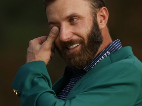Dustin Johnson of the U.S. celebrates with his green jacket after winning The Masters.