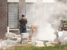 Windsor's unemployment rate rose last month. Here, masonry workers labour outside on Silver Maple Road on July 10, 2020.