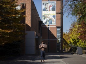 A man wearing a mask walks outside the CAW Student Centre on a nearly empty University of Windsor campus, Tuesday, Nov. 3, 2020. The university has its first in-house COVID-19 case.