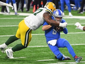 Kenny Clark of the Green Bay Packers tackles Matthew Stafford of the Detroit Lions during the second half at Ford Field on December 13, 2020 in Detroit, Michigan.