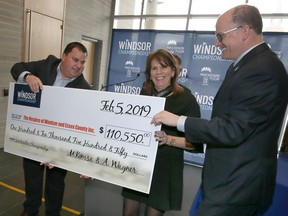 In this Feb. 5, 2019, photo, Hospice of Windsor and Essex County executive director Colleen Reaume, receives a donation from Adam Wagner, left, of Windsor Championship, at a city hall presentation as Windsor Mayor Drew Dilkens looks on.