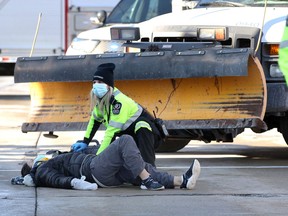 Essex-Windsor EMS paramedics attend to a woman who was involved in a collision with a snow plow on Wyandotte Street East at St. Rose Avenue Tuesday.  The woman did get to her feet on her own, but was placed on a stretcher and taken to hospital for assessment.