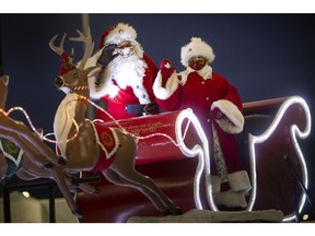 Santa Claus and Mrs. Claus wave at cars passing by during the 52nd Annual Windsor Santa Claus Parade presented in a drive-by format at St. Clair College, Saturday, Dec. 6, 2020.