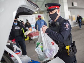 Windsor Police Sgt. Andy Drouillard loads donated food items into a police cruiser for the Stuff-a-Cruiser Gift Card and Food Drive outside the Real Canadian Superstore on Dougall Avenue, Saturday, Dec. 6, 2020.