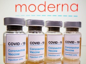 Vials with a sticker reading "COVID-19 / Coronavirus vaccine / Injection only" are seen in front of a Moderna logo in this illustration taken Oct. 31, 2020.