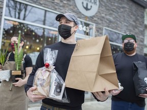 Owners of Anchor Coffee, from left, Rachel Bondy, Ryan Larocque, and Kyle Bondy, hold items for sale for Christmas, Sunday, Dec. 20, 2020. Some essential small businesses are offering specialty items since many stores are closed due to the lockdown.