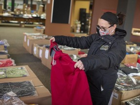 Kristi Provost is shown on Friday, Dec. 11, 2020, browsing through donated clothing items that are currently being sold through the Downtown Mission's social enterprise Chari-tees at the former central library branch. Proceeds from the sales of the donated items worth over $400,000 will support programs of the Downtown Mission. The sale takes place all weekend.