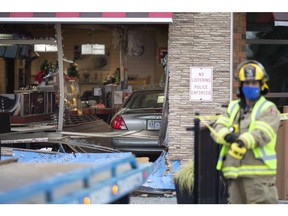 Emergency crews work at the scene where a vehicle was driven into the dining area of Tim Hortons in Belle River, Thursday, Dec. 24, 2020.  No injuries are reported.