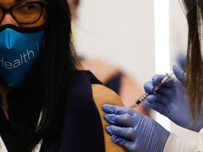 Dr. Marina Del Rios (L), from University of Illinois Hospital & Health Sciences System, reacts as she receives Chicago's first COVID-19 vaccination from Dr. Nikhila Juvvadi at Loretto Hospital, on December 15, 2020 in Chicago, Illinois.