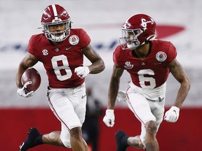 ARLINGTON, TEXAS - JANUARY 01: Wide receiver John Metchie III #8 of the Alabama Crimson Tide carries the football behind the wide receiver DeVonta Smith #6 against the Notre Dame Fighting Irish in the 2021 College Football Playoff Semifinal Game at the Rose Bowl Game presented by Capital One at AT&T Stadium on January 01, 2021 in Arlington, Texas.