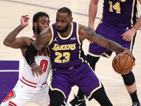LeBron James of the Los Angeles Lakers dribbles past Coby White of the Chicago Bulls during the second half of a game at Staples Center on January 08, 2021 in Los Angeles, California.