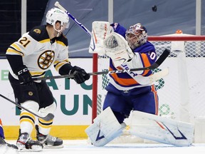 Nick Ritchie of the Boston Bruins watches a shot sail over Semyon Varlamov of the New York Islanders during the second period at the Nassau Coliseum on January 18, 2021 in Uniondale, New York.