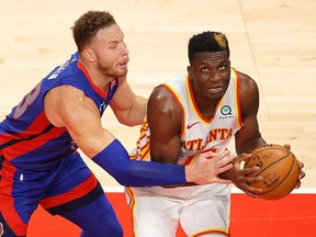 Clint Capela of the Atlanta Hawks draws a foul as he scores a basket against Blake Griffin of the Detroit Pistons during overtime at State Farm Arena on January 20, 2021 in Atlanta, Georgia.