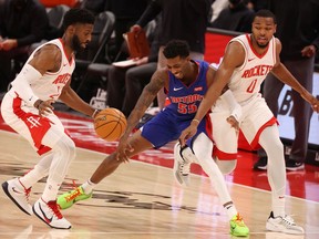 Delon Wright of the Detroit Pistons loses control of the ball between David Nwaba and Sterling Brown of the Houston Rockets during the second half at Little Caesars Arena on January 22, 2021 in Detroit, Michigan.