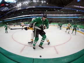 John Klingberg of the Dallas Stars skates for the puck against Yakov Trenin of the Nashville Predators in the third period at American Airlines Center on January 22, 2021 in Dallas, Texas.