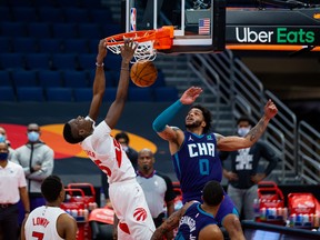 Toronto Raptors forward Chris Boucher dunks over Charlotte Hornets forward Miles Bridges on Thursday.