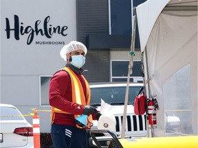 An employee acting as COVID-19 monitor for Highline Mushrooms in Leamington, shown June 10, 2020, prepares to disinfect the expanded space for migrant workers following lunch.