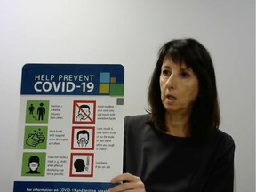 In this Aug. 13, 2020, file photo, Windsor-Essex County Health Unit CEO Theresa Marentette is shown at a virtual news conference, holding up signage created by WECHU for municipal facilities to help spread the message on how to prevent the spread of COVID-19.