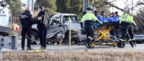 Essex-Windsor paramedics and Lakeshore firefighters rescue the driver of a pickup truck, right, following a collision with a tractor-trailer carrying an excavator on Manning Road just south of the intersection with County Road 34. A woman was rescued from the van and placed on a spine board and stretcher, then transported to hospital.  The incident happened in an 80 km/h zone on Manning Road.