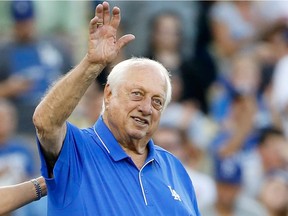 Los Angeles Dodgers legend Tommy Lasorda waves to the crowd before he throws out the ceremonial first pitch before the Dodgers take on the New York Mets in game two of the National League Division Series at Dodger Stadium on Oct. 10, 2015 ,in Los Angeles, California.